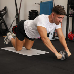 Man in a gym musing a Duo Ab Wheel for core fitness training