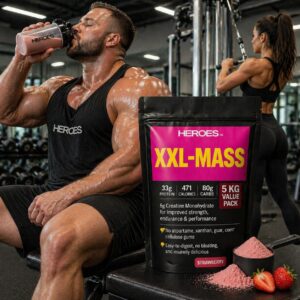 Muscular man drinking strawberry Heroes XXL Mass whey gainer shake in modern gym with woman working out behind